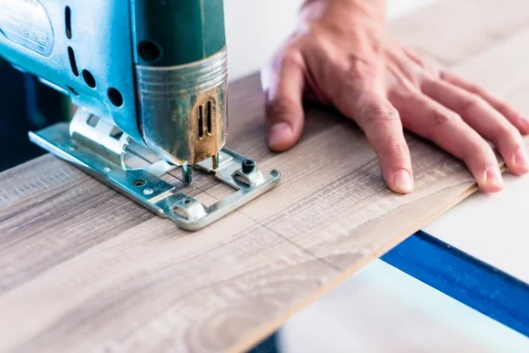 Person sägt Holz mit Stichsäge